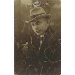   Elegáns, tehetős fiatalember kalapban cigarettával. Műtermi felvétel, fotólap. 1920-as, 1930-as évek. (2791903)