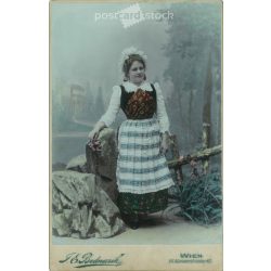   1902 - F. E. Bednarik fényképészeti műterem, Bécs. Fiatal nő egészalakos fotója ünnepi, népies öltözékben. Színezett kabinetfotó / keményhátú fotó / vizitkártya, CDV fotó. (2792098)