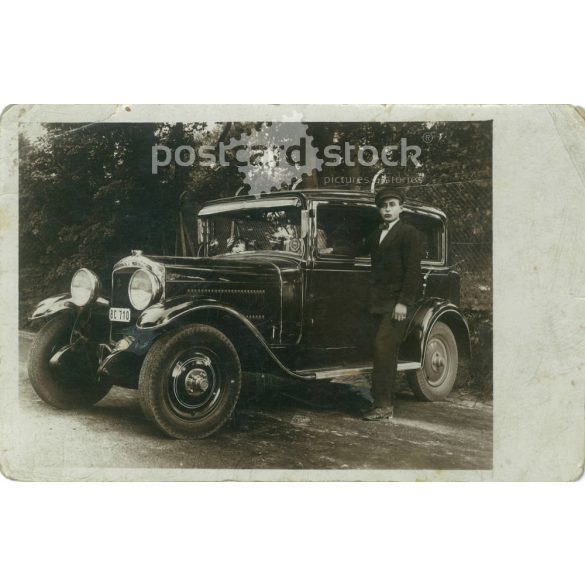 1931 - Az autó és fiatal sofőrje. A szélvédőn matrica: „Közúti Autóbélyeg 1934” felirattal. Fekete-fehér fotólap, képeslap. (2792164)