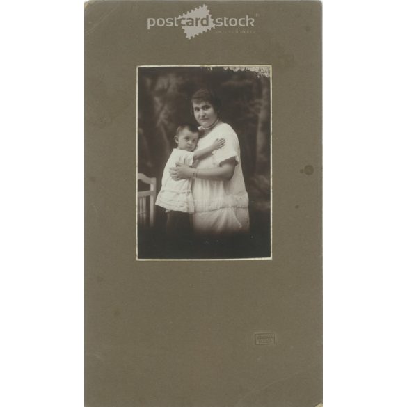 1910-es évek. Édesanya gyermekével, műtermi felvétel. Készült Homonnai, fényképészeti műtermében, Makó. Eredeti, kasírozott papírkép. (2792264)