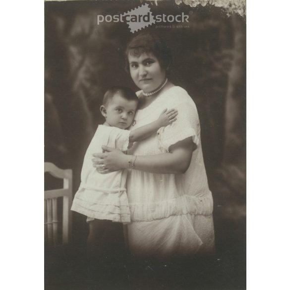 1910-es évek. Édesanya gyermekével, műtermi felvétel. Készült Homonnai, fényképészeti műtermében, Makó. Eredeti, kasírozott papírkép. (2792264)
