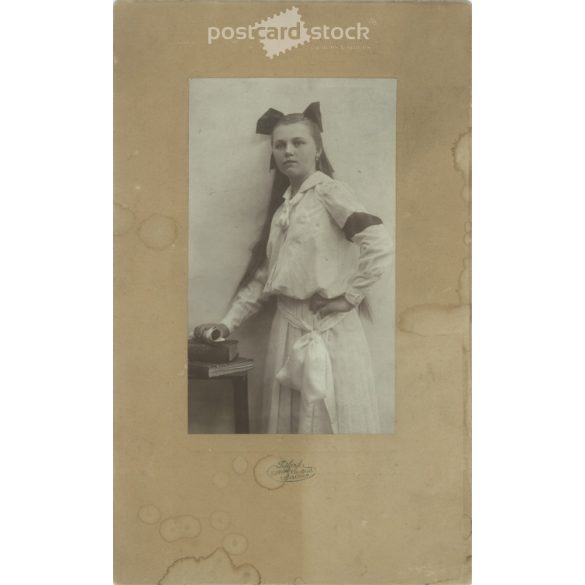 1905 - Leány masnival, fehérben. Szombathely. Fekete-fehér eredeti kasírozott papírkép, régi fotó. A képet Szilárd Tódor fényképészeti műterme készítette. (2792412)