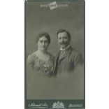 1910-es évek. Házaspár, műtermi fotója. A képen szereplők személye ismeretlen. A fotó Schmidt Ede fényképészeti műtermében készült, Budapesten. Régi fotó, eredeti kabinetfotó / keményhátú fotó. (2792680)