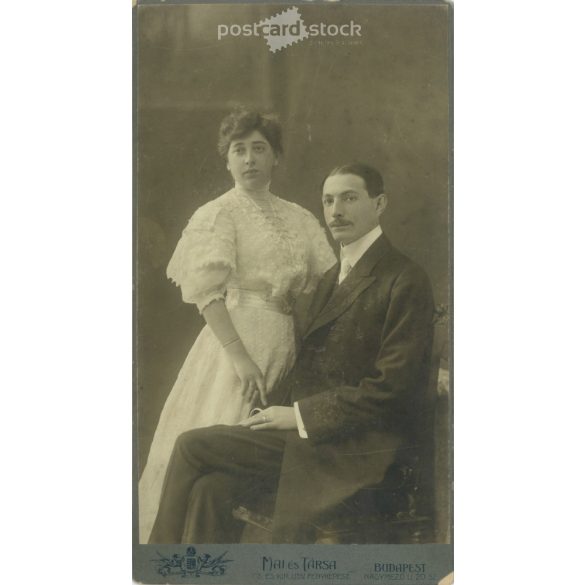 1908 október. Fiatal pár műtermi felvétele. A képen szereplők személye ismeretelen. A kép készítője Mai és Társa fényképészeti műterme. Régi fotó, eredeti kabinetfotó / keményhátú fotó. (2792783)