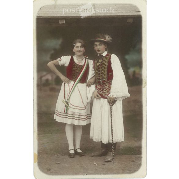 1910-es évek. Fiatal pár népviseletben, Martonvásár. A képen szereplők és a kép készítője ismeretlen. Eredeti régi fotó. Színezett fotólap, régi képeslap. (2793611)